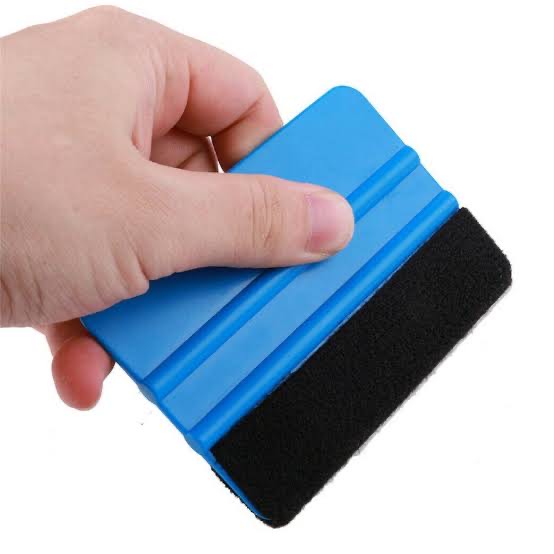 Blue sticker applicator squeegee held in hand, used for smooth vinyl sticker installation, supplied by Docuprint in Fremantle, Perth, Australia