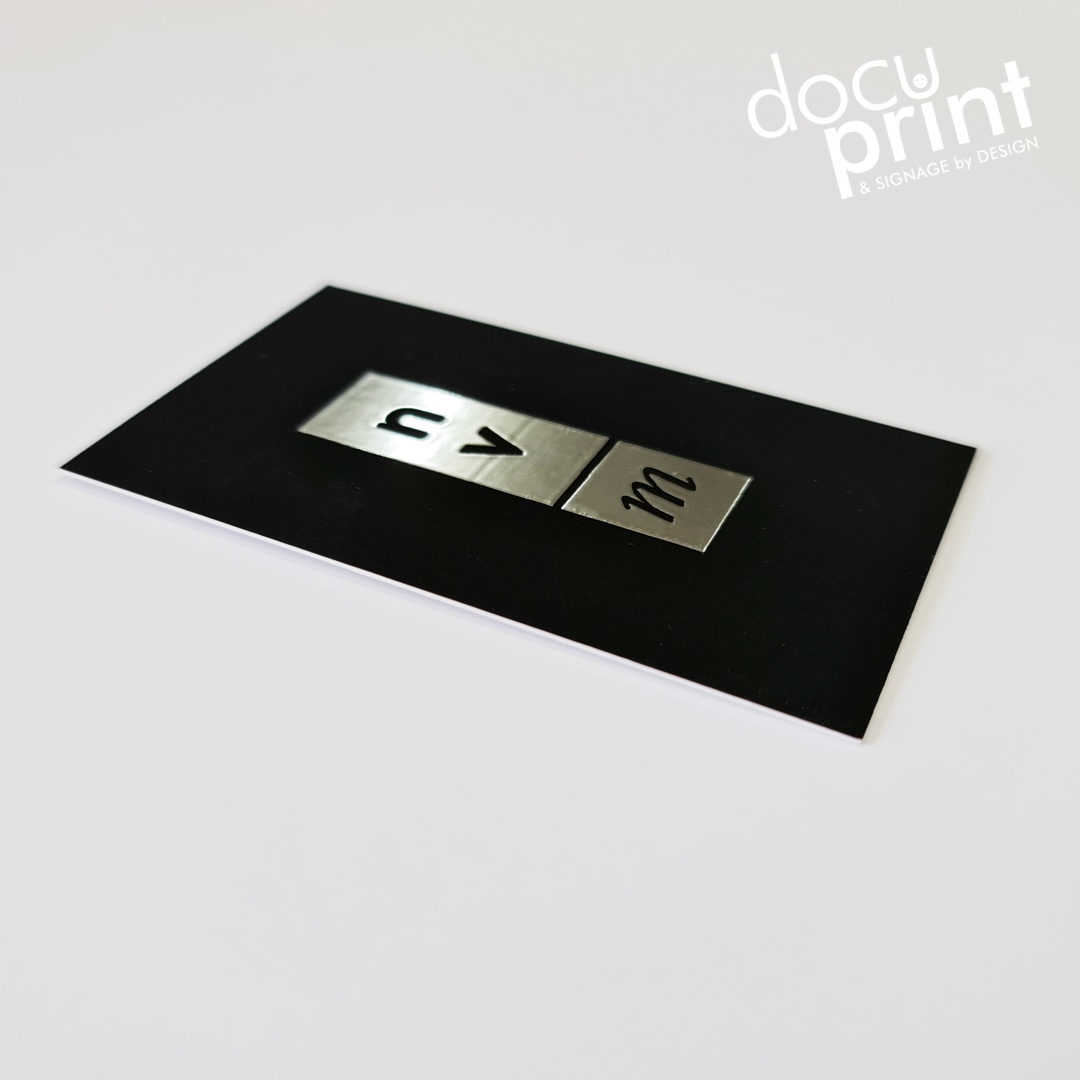 A business card with a raised UV foil finish, featuring gold or silver accents on a black background, custom designed and printed by Docuprint in Fremantle, Perth, Australia