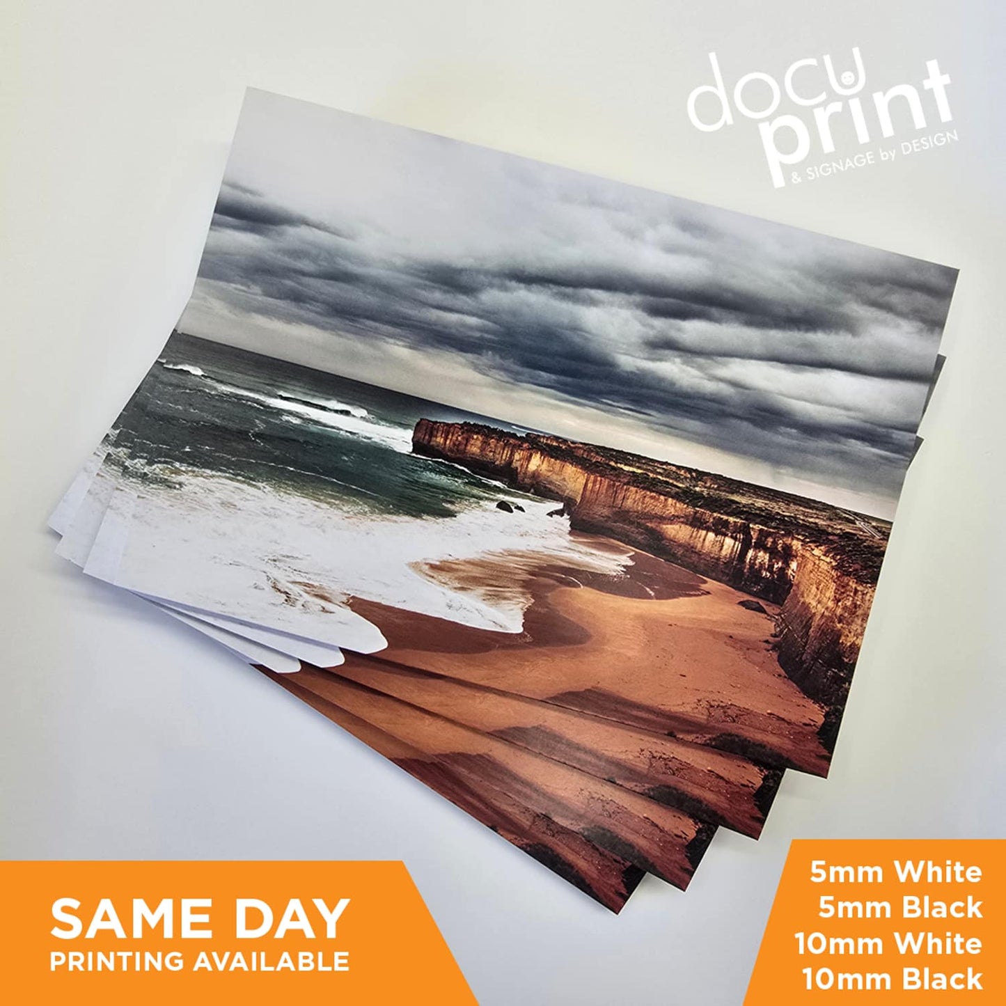 Stack of foamboard posters featuring a beach and cliff scene, professionally printed and finished by Docuprint in Fremantle, Perth, Australia