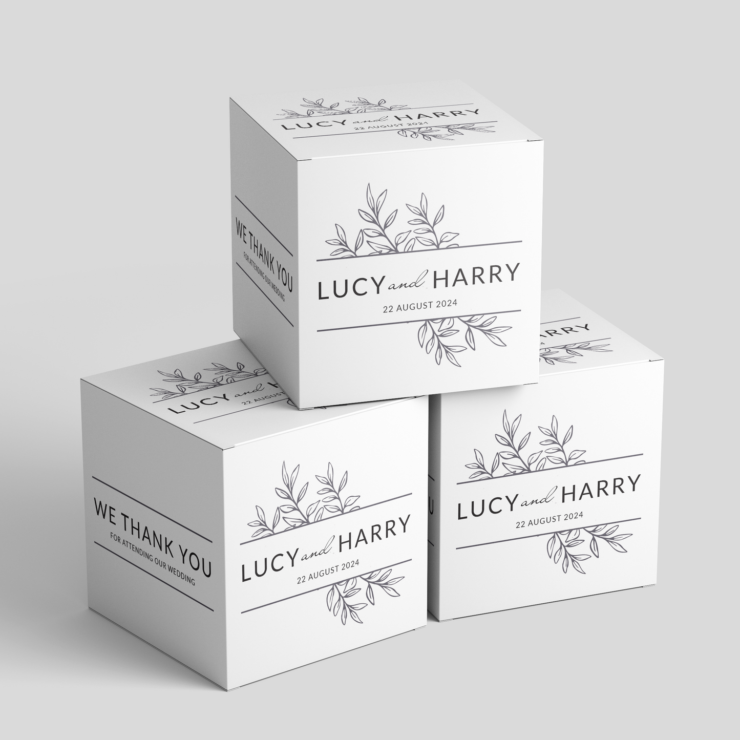 Custom party favor boxes with a design featuring a leaves and text 'Lucy and Harry' for a wedding, stacked in a pyramid shape, custom designed and printed by Docuprint in Fremantle, Perth, Australia.