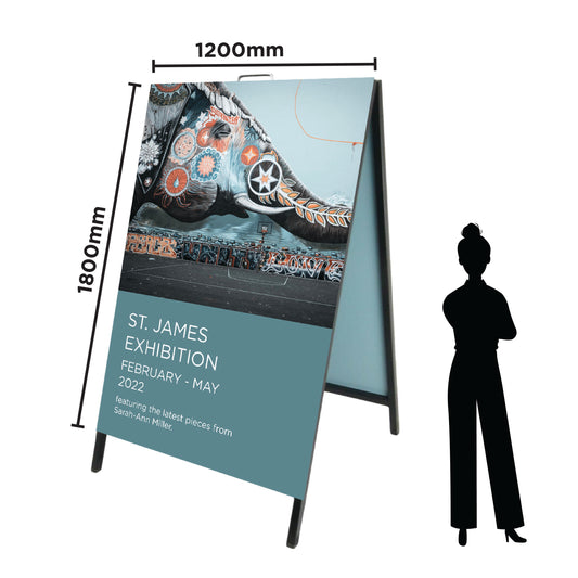Large A Frame sign featuring an art exhibition, custom designed and printed by Docuprint in Fremantle, Perth, Australia. The sign is standing next to a cartoon image of a woman to show that is is taller than a person. 