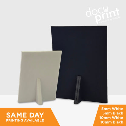 An image showing the back of a foamboard sign, where there are easy stands so they can sit on countertops, A5 Saddle stitched booklets featuring a beauty clinic, custom designed and printed by Docuprint in Fremantle, Perth, Australia. Sitting on a white surface, with green plants next to it. 
