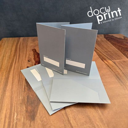 grey hotel key card holders spread out on a wooden table. Custom made, designed and printed by Docuprint Fremantle in WA. 