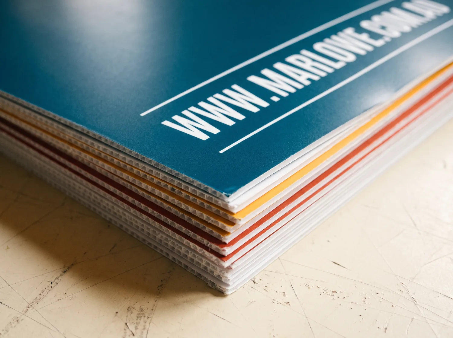 Stack of freshly printed corflute signs showing the fluted edge